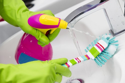 A person organizing a room as part of a regular cleaning routine